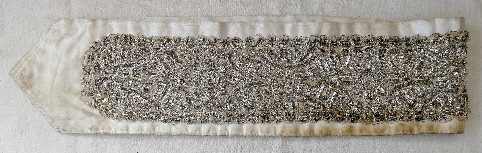Antique crown for a tallit made of cloth with silver thread embroidery on it.: Antique crown for a tallit made of cloth with silver thread embroidery on it. Length: 110 cm. (43.3 inches), width: 14 cm. (5.5 inches) Condition: use wear. some threads detached and worn, brown stain