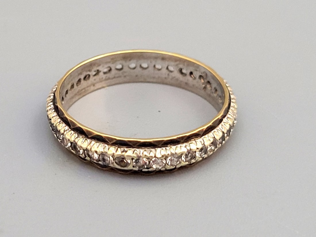Gold and Silver Eternity Tennis Ring Set with Diamonds: Gold and silver tennis eternity ring set with round cut diamonds of approximately 1 point around, totaling approximately half a carat of diamonds, signed, size 8, weight: 2.8 grams.