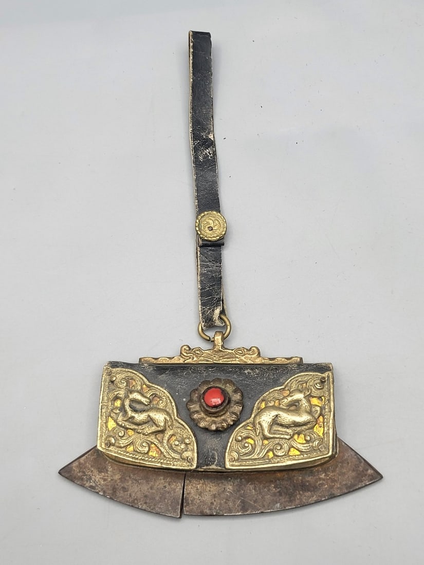 An old Tibetan miniature carrying pouch bag for carrying coins/objects: An old Tibetan miniature carrying pouch bag for carrying coins/objects, 20th century, made of leather and metal parts: silver and brass hand-hammered in an animal and plant patterns, in the center a c