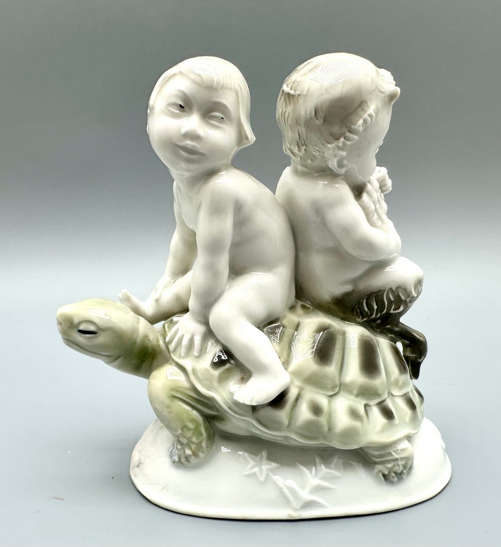 Wilhelm Heider (1882-1955) for Roenthal - Child (putty) and satyr riding a turtle: Wilhelm Heider (1882-1955) for Roenthal - a boy (putty) and a satyr riding a turtle, high-quality art deco porcelain figure, circa 1930s, decorated with high-quality hand-painting, signed on the botto