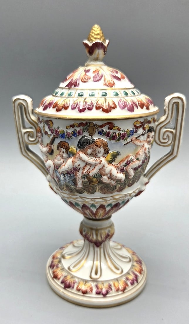 High-quality Antique Capodimonte Porcelain Amphora Vase: High-quality Antique Capodimonte Porcelain Amphora Vase, Italy, 19th century. Decorated with colorful enamel reliefs and hand paintings of playing angels and neoclassical floral motifs. Gilded accents
