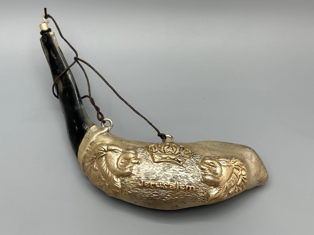 Silver-Decorated Ram's Horn Shofar (Left-Leaning): Ram's horn shofar decorated with electroformed silver featuring lions, a Torah crown, and "Jerusalem." Decorative use only (sealed). Signed "S.C." Width: 28 cm. 306 g. New from store liquidation. Smal