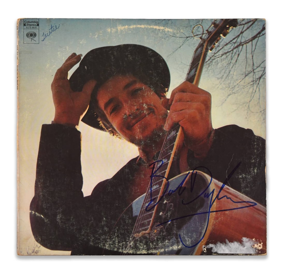 BOB DYLAN - Signed Nashville Skyline LP: BOB DYLAN - SIGNED NASHVILLE SKYLINE LP Provenance and Authenticity: The front cover bears a large blue ink signature reading "Bob Dylan," positioned prominently across the lower right portion of the