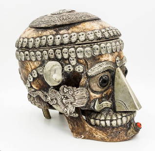 A Ceremonial Kapala Scull, Tibet, 19th Century: A Ceremonial Kapala Scull, Tibet, 19th Century Description: A human skull decorated with silver ornaments throughout. The eyes set with onyx. The scalp opens to reveal a silver-plated bowl. Height: 16