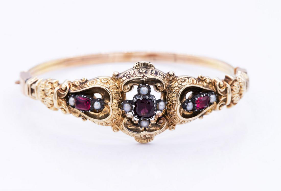 A Biedermeier 18K Gold Ruby and Pearl Bracelet: A Biedermeier 18K Gold Ruby and Pearl Bracelet The top designed with open work rocaille and set with rubies and seed pearls. Diameter: 6 cm; total weight: 11.66 gr Condition: For a deta