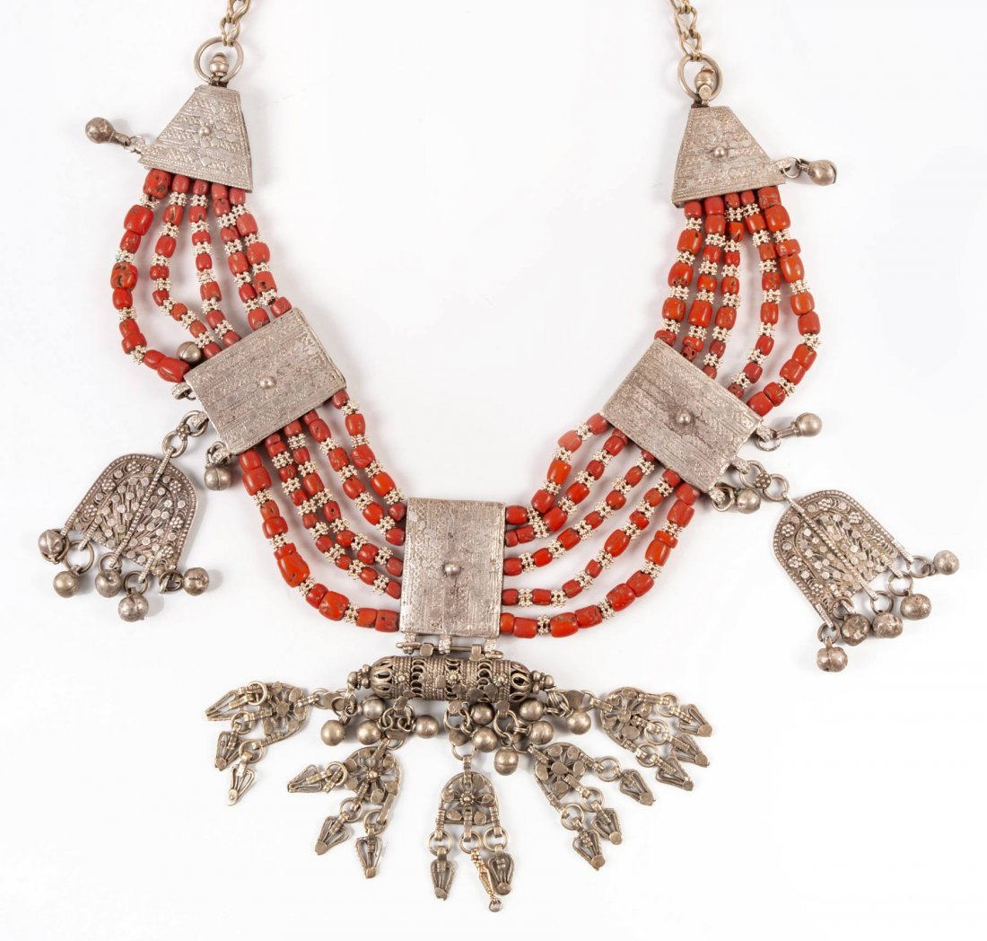 A Silver and Coral "Lazem" Necklace, Yemenite, 19th c: A Fine Silver and Coral "Lazem" Necklace, Yemenite, 19th Century Composed of five engraved, silver plates connected by five rows of coral and silver granules beads. The three central silver plates ter