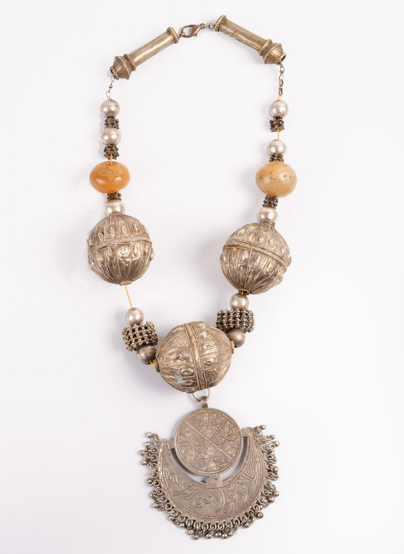 A Fine Silver and Agate Pendant Necklace, Yemenite,: A Fine Silver and Agate Pendant Necklace, Yemenite, 19th Century Composed of large spherical beads decorated with filigree work alternating by smaller granule and antique agate beads. Centered by a cr