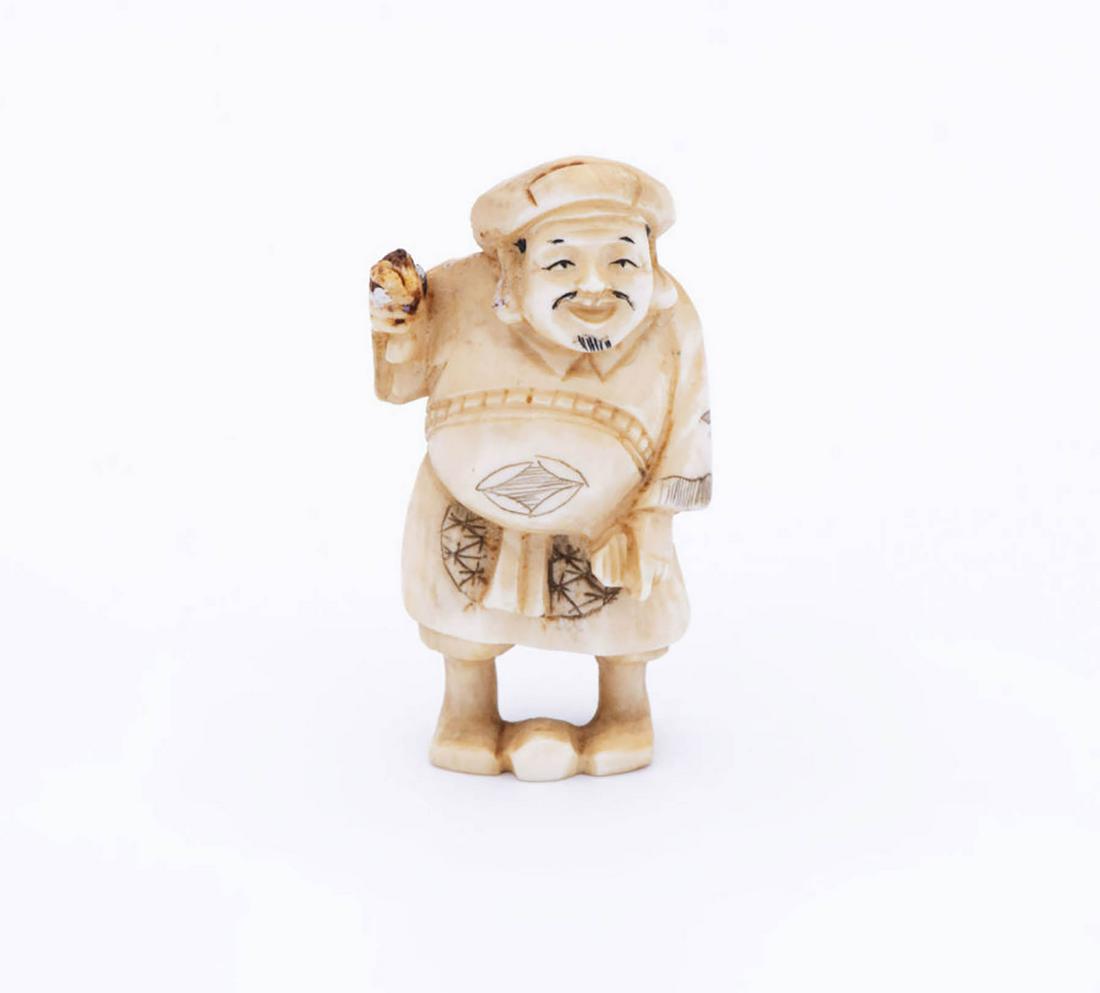A Carved Katabori Netsuke of a Merchant, Japan, 20th: A Carved Katabori Netsuke of a Merchant, Japan, 20th Century Signed (on the underside). 5 cm