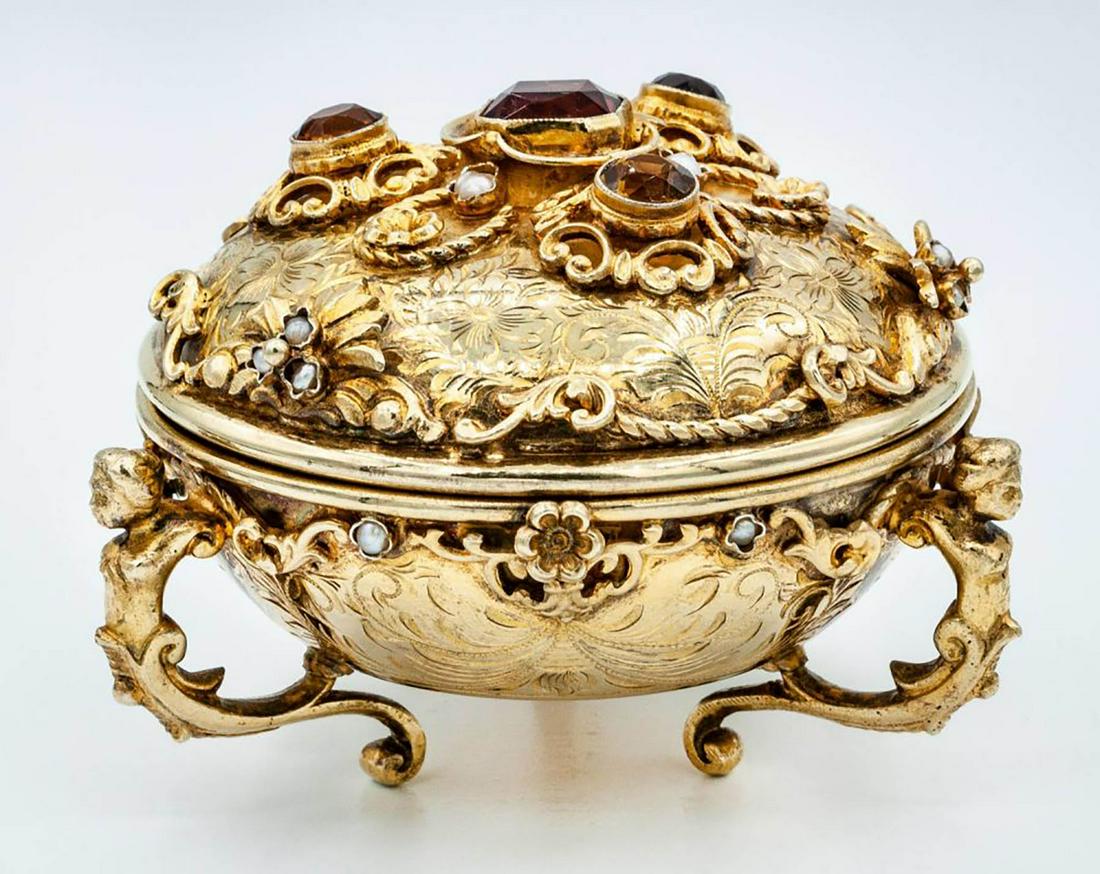 A Fine Silver Gilt Trinket Box, Italy, Late 19th-Early: A Fine Silver Gilt Trinket Box, Italy, Late 19th-Early 20th Century Description: Set on three curved, scroll-shaped supports and engraved throughout with rocaille. The lid and rims set with topaz and 