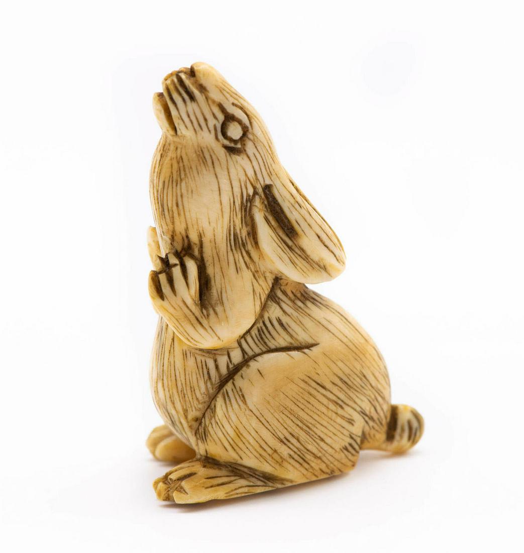 A Charming Japanese Carved Netsuke of a Rabbit on: A Charming Japanese Carved Netsuke of a Rabbit on Hind Legs, 19th Century Standing on hind legs. Signed Yoshikawa (on the underside). Height: 4.8 cm Condition: Fo