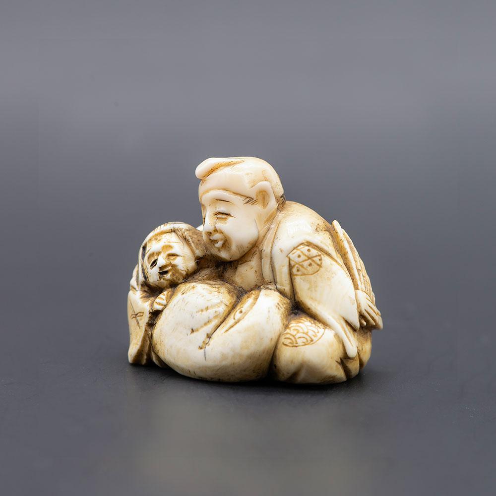 A Carved Netsuke of a Family, Early Meiji Period: A Carved Netsuke of a Family, Early Meiji Period (1868-1912) Signed (on the underside). Height: 4 cm; width: 4.5 cm Condition: For a detailed condition r
