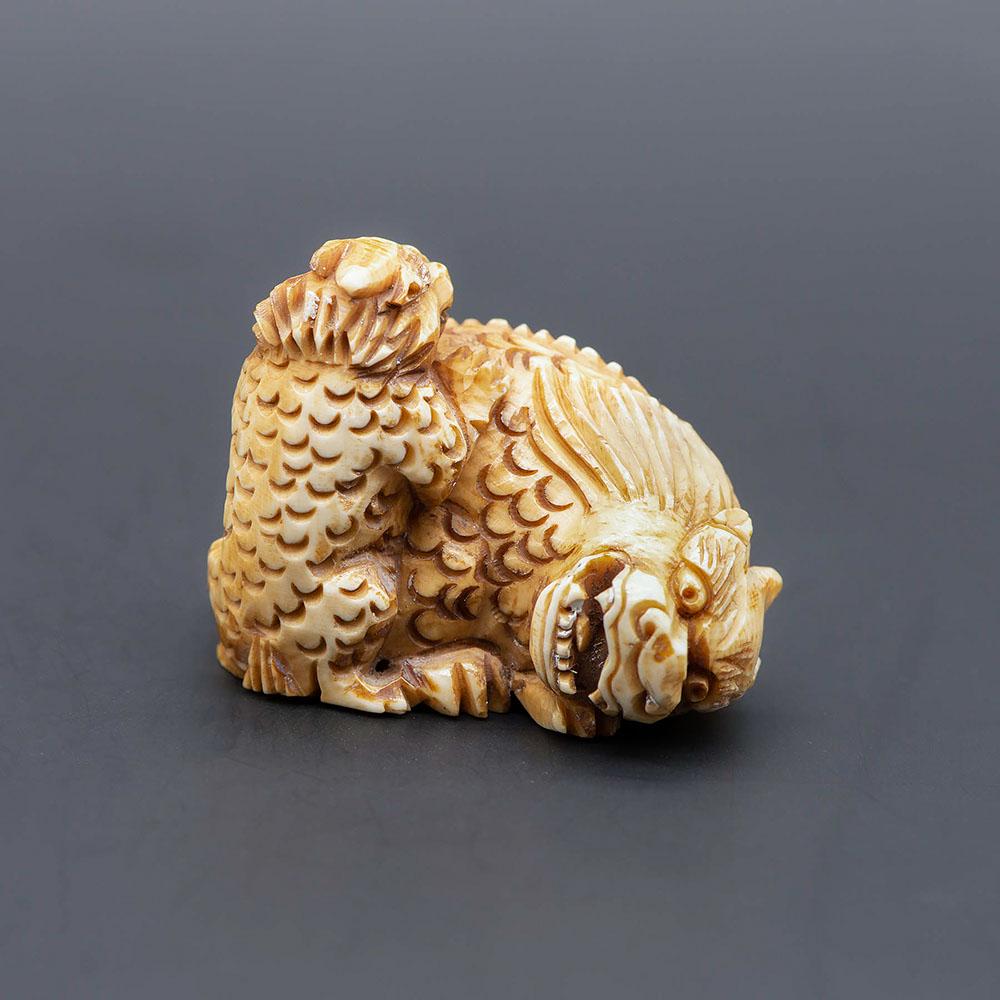 A Carved Netsuke of a Baku with Offspring, Kioto: A Carved Netsuke of a Baku with Offspring, Kioto style Height: 3.2 cm Condition: For a detailed condition report, please contact us at info@hammersite.com