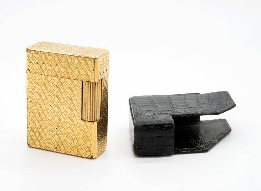 A Vintage ST Dupont Paris Gold Plated Lighter: A Vintage ST Dupont Paris Gold Plated Lighter The body embossed with a geometric pattern. Including a fitted case. Fully marked. 4.7 x 3.4 cm Condition: For a detailed condition report, please co
