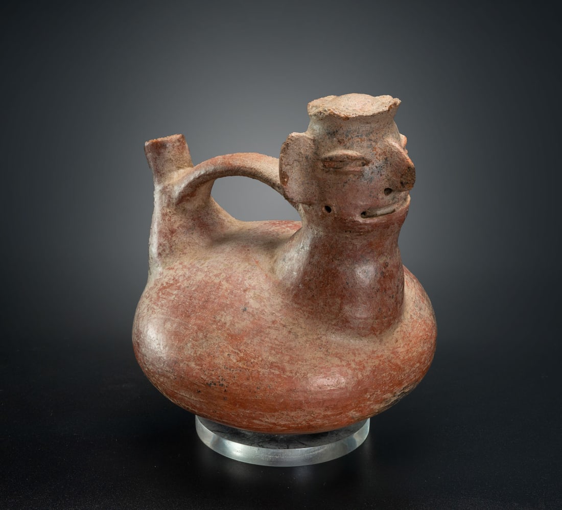 An Anthropomorphic Whistling Bottle, Vicus, Peru, 200 BCE-800 CE: An Anthropomorphic Whistling Bottle, Vicus, Peru, 200 BCE-800 CE Height: 19 cm For more details on this lot refer to the following number in the link: num 139, p. 154 (