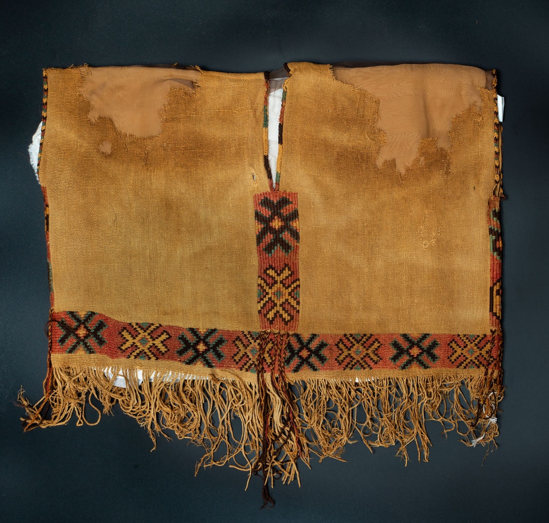 A Sleeveless Tunic with Geometric Design, Ica Valley Peru, Middle Horizon, 500-700 CE: A Sleeveless Tunic with Geometric Design, Ica Valley Peru, Middle Horizon, 500-700 CE Late Nasca or Nasca-Huari Orange, yellow, blue and brown cross-knit loop stich camelid fiber. 49 x 60 cm