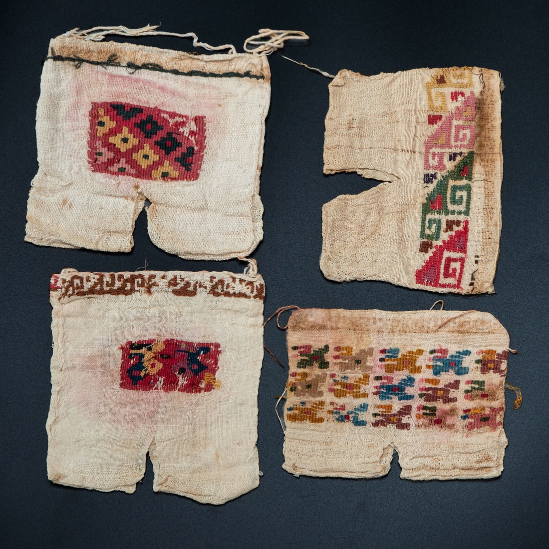 Four Miniature Shirts, North Coast, Peru, Possible Middle Horizon, 100-800 CE: Four Miniature Shirts, North Coast, Peru, Possible Middle Horizon, 100-800 CE Moche Multicolored plain weave cotton. a. 10.5 x 13 cm b. 10 x 13 cm c. 13 x 13.5 cm d. 14 x x12.5 cm