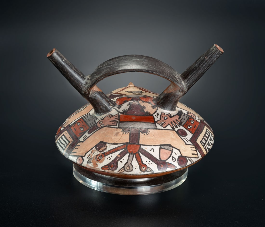 A Double Spout-and-Bridge Bottle Painted with a Mythological Scene, Late Nasca, Peru, 300-600 CE: A Double Spout-and-Bridge Bottle Painted with a Mythological Scene, Late Nasca, Peru, 300-600 CE A unique complex scene showing a naked supine male with elaborate headdress, surrounded by humans, bein