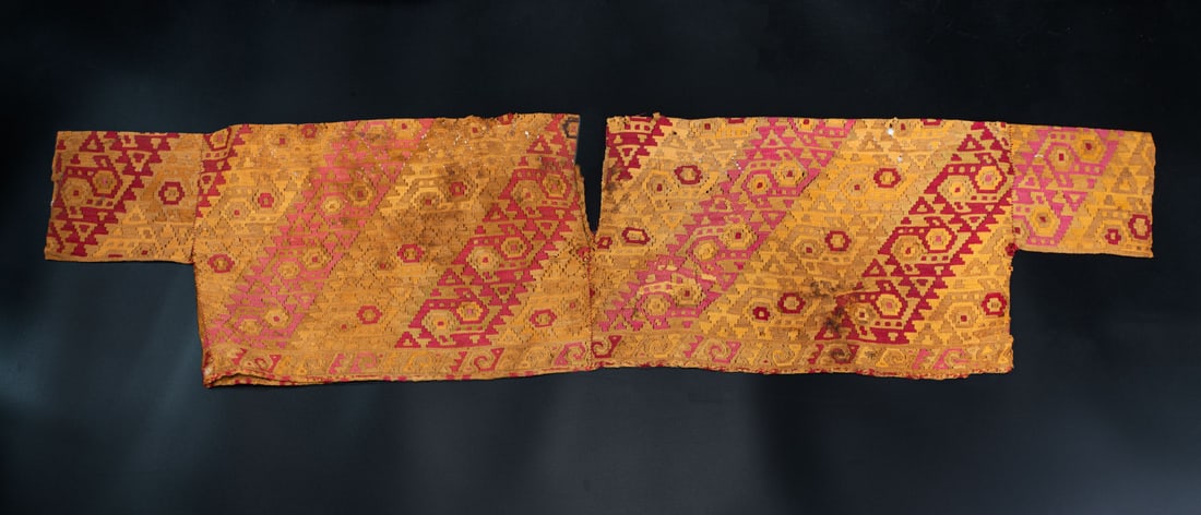 A Sleeved Shirt Decorated with Interlocking Birds, North/Central Coast, Peru, Late Horizon,: A Sleeved Shirt Decorated with Interlocking Birds, North/Central Coast, Peru, Late Horizon, 1350-1530 CE Chimu Brown cotton and multicolored camelid fiber slit tapestry. 32 x 130 cm (e
