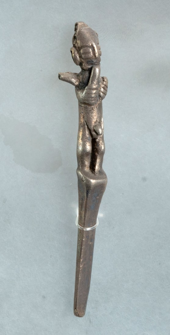 A Silver Spatula with Man Figurine, Chimu, Peru, 900-1470 CE: A Silver Spatula with Man Figurine, Chimu, Peru, 900-1470 CE Silver lime spatula with modeled depiction of a naked male on its top. Height: 8.3 cm For more details on this lot refer to the following n