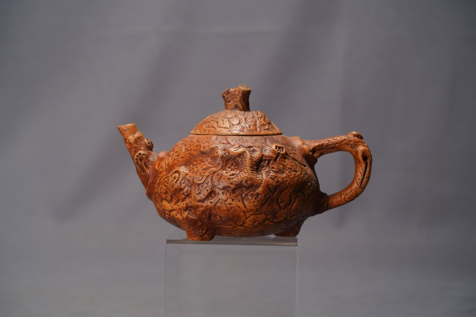 Chinese fine teapot: Chinese fine clay teapot, with outside carving in an unusual form. H: 4.75" x W: 8.8"