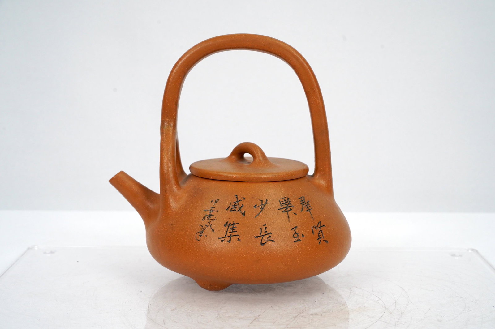 Chinese orange teapot: Chinese vintage orange clay clay teapot, with calligraphy carvings. H: 6.75" x W: 6.25"