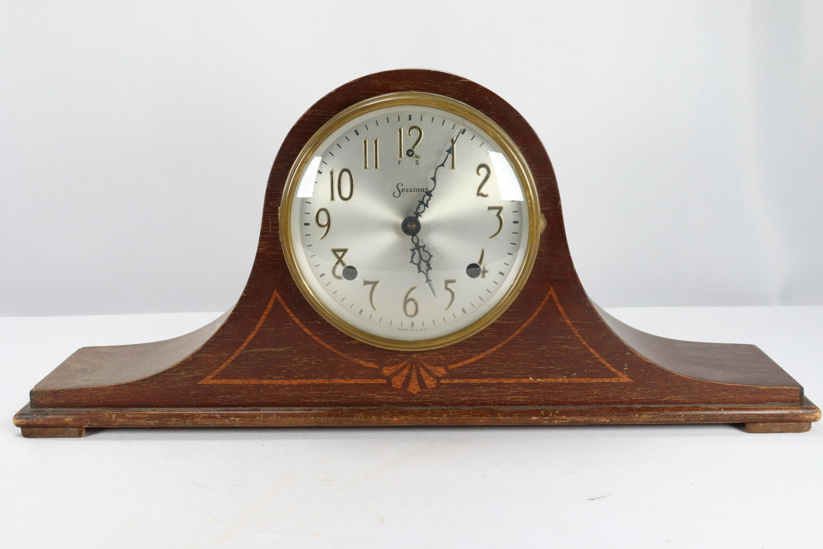 A wooden mantle clock: A wooden mantle clock, condition selling it as is, and not sure if its working. H: 9.25" x W: 21.25"