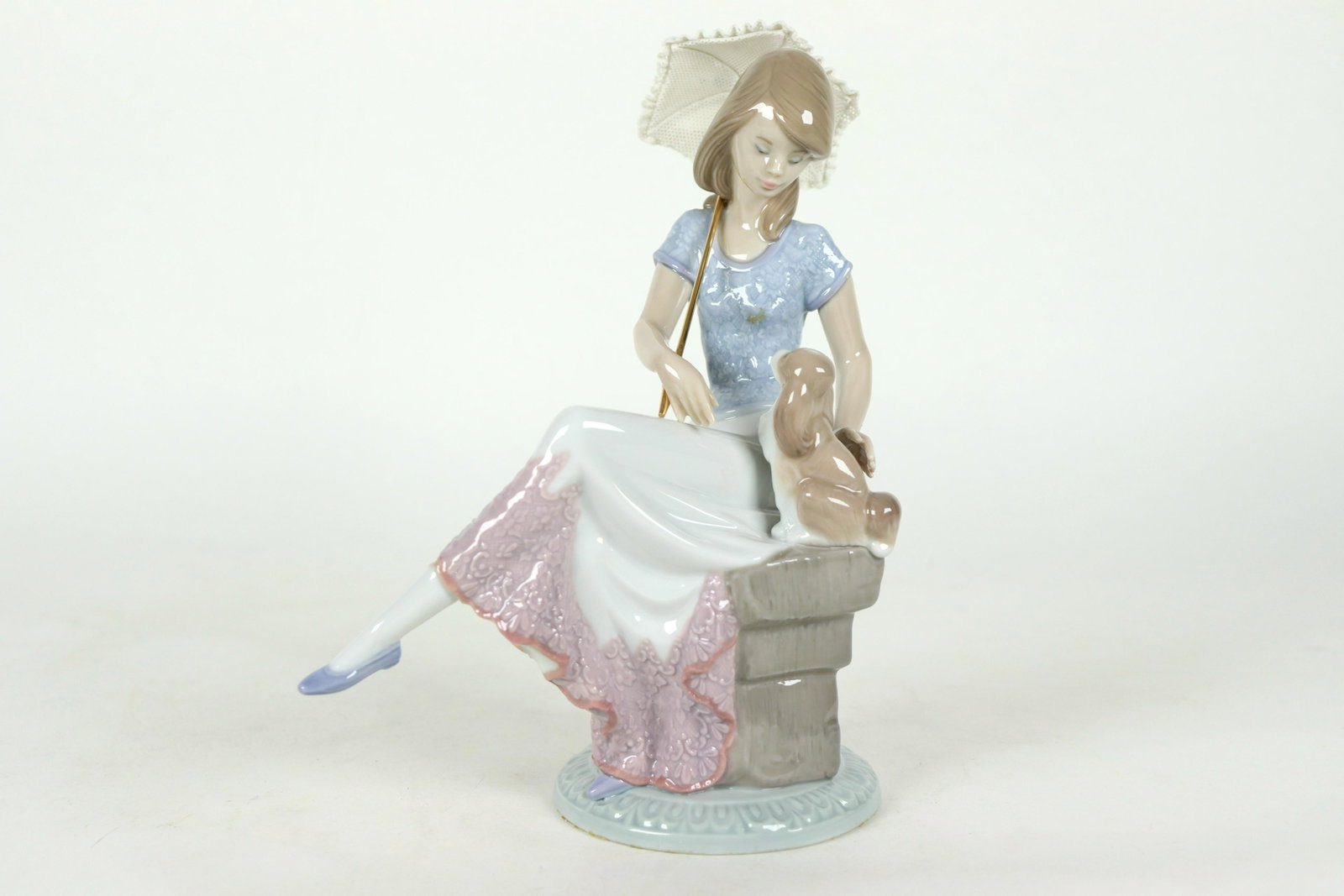 Lladro woman with umbrella: Lladro woman with umprella figurine. Comes with original box. H: 8.75" x W: 6.5."