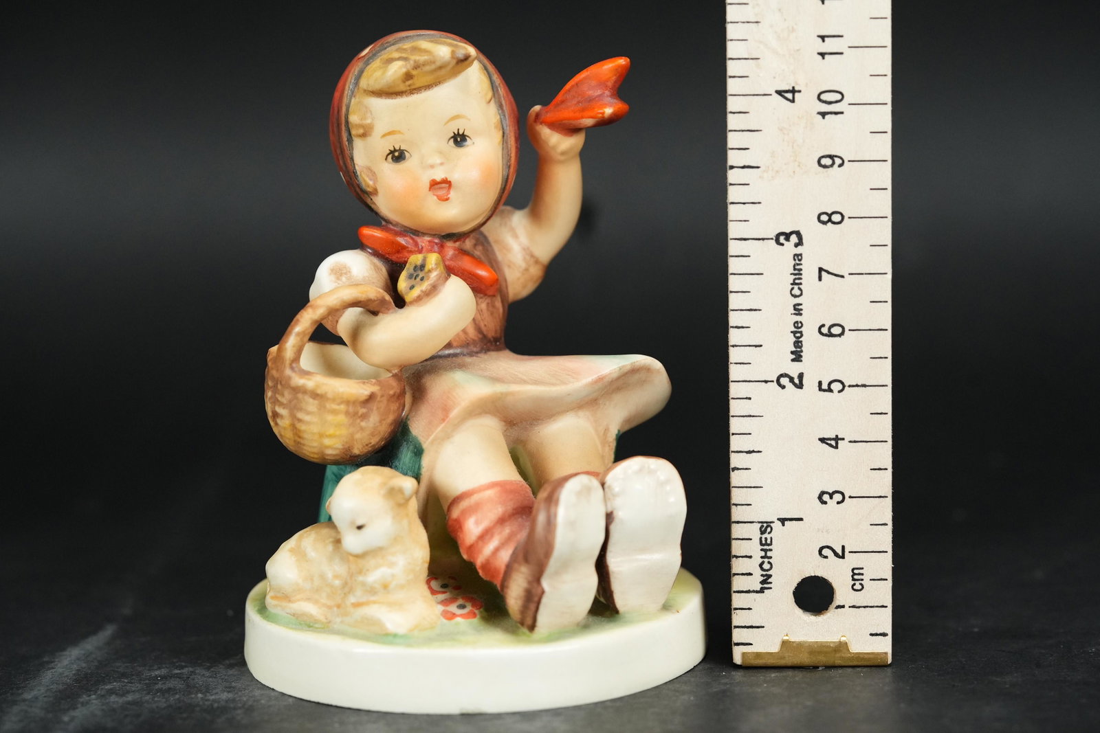 A Hummel girl figurine: A vintage Hummel girl figurine with a basket. H: 4.75" x W: 3.4."