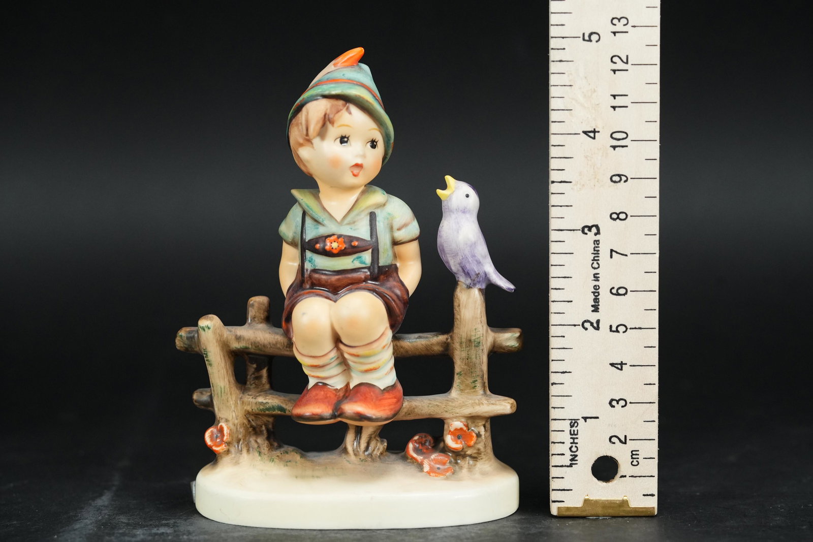 A vintage Hummel figurine: A vintage Hummel figurine, of a boy sitting by a bird. W. Germany. Dated 1989.H: 5.2" x W: 4."