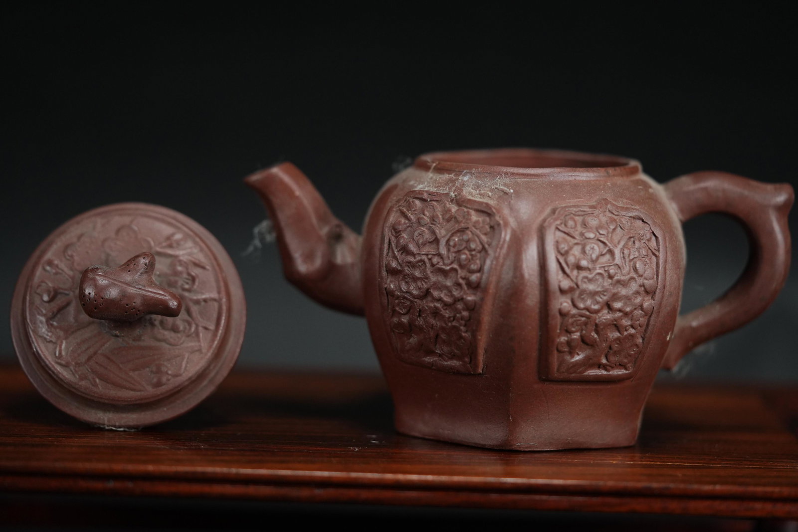 Chinese dark clay teapot: Chinese dark clay teapot with carvings. H: 4.75" x W: 6.5."