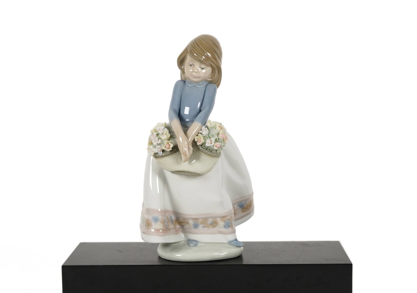 Lladro girl with flower: Lladro girl with flower figurine. H: 7" x W: 4.25."