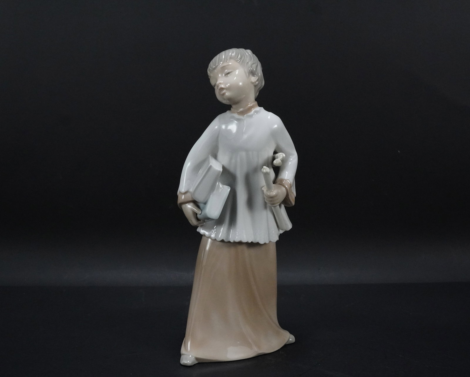 Lladro boy with books: Lladro boy with books figurine. H: 9" x W: 4."