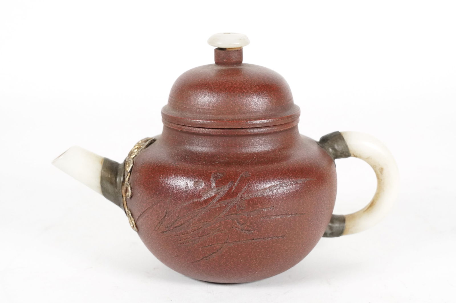 Chinese clay teapot: Chinese clay teapot with jade spout. H: 4.2" x W: 6.2."