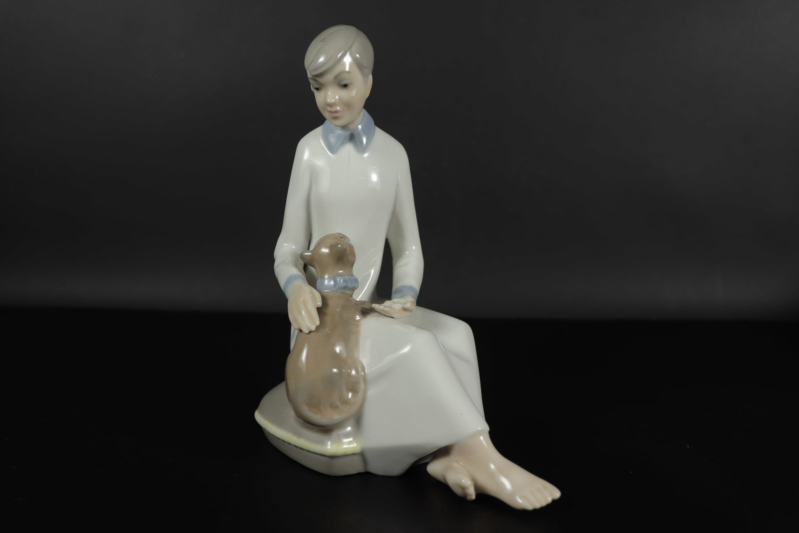 A boy with dog figurine: A boy with dog fine figurine. H: 7" x W: 5.5."