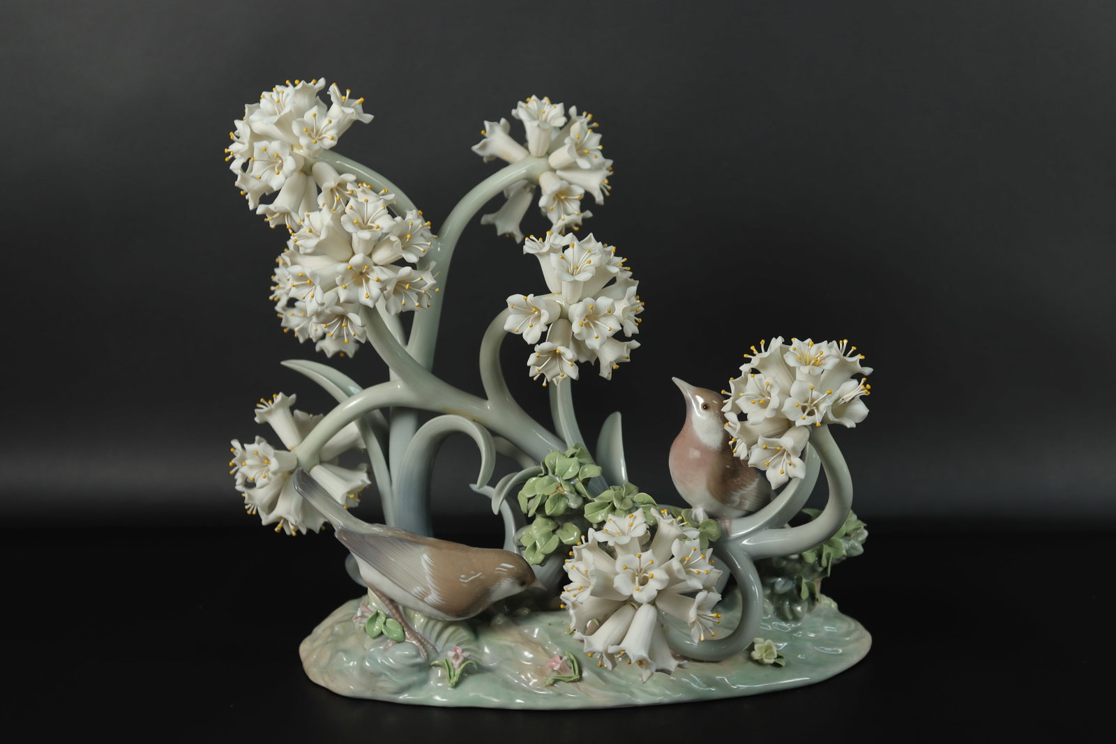 Lladro fine figurine: Lladro fine and rare figurine, with flowers and bird. Some of the flowers are missing, condition selling it as is. H: 10" x W: 9.5."