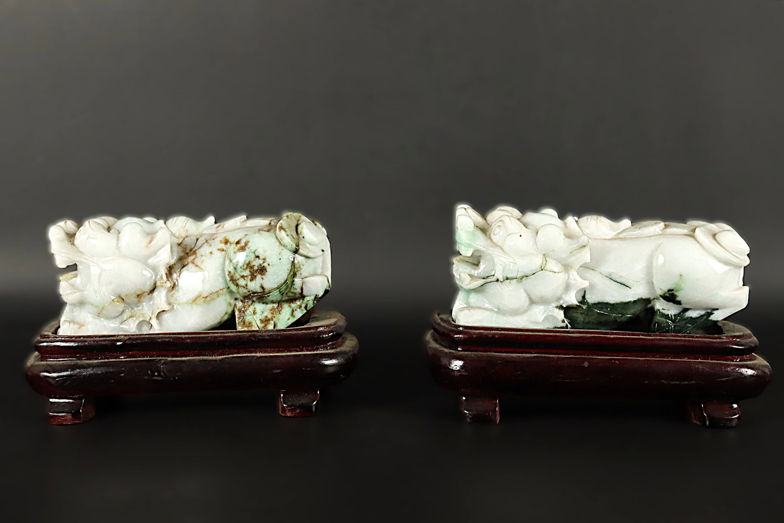 2 Chinese jadeite foo lion: 2 Chinese fine jadeite carved foo lion with wooden stand. H: 3.8" x W: 5.5."