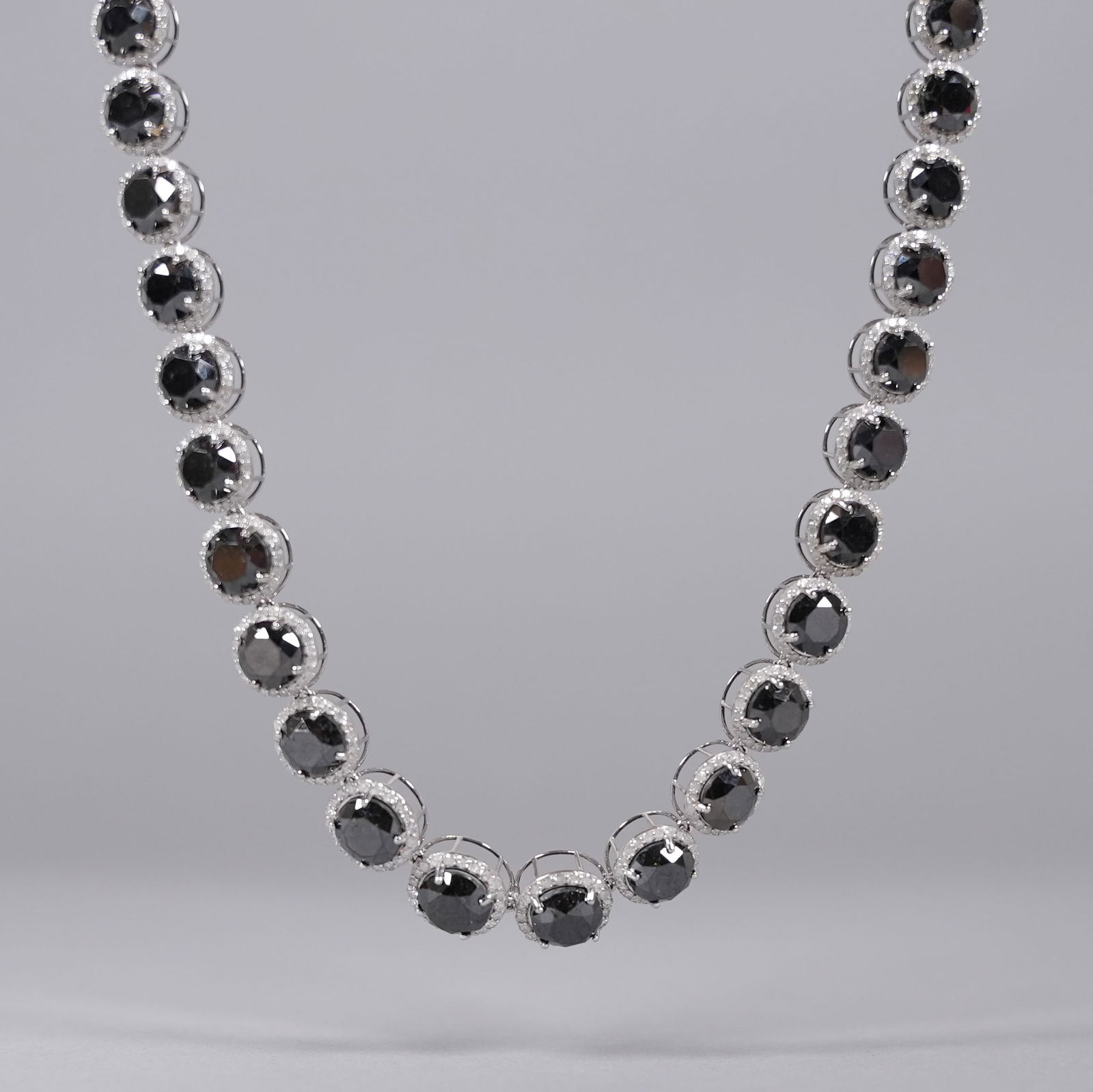 14 kt white gold black diamond necklace: 14 kt white gold brilliant cut black round diamonds with colorless diamonds necklace. Total 111.27 carats black diamonds. Total 9.41 carats colorless diamonds.