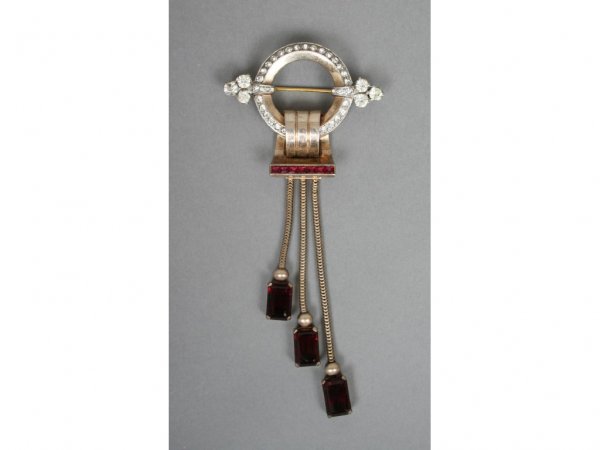 Mazer Art Deco Costume Brooch: Cast in sterling, set with rhinestones and faux rubies, hallmarked sterling Mazer, #6. 5"H. 2 1/4"W. Condition: excellent, no damage or repair.