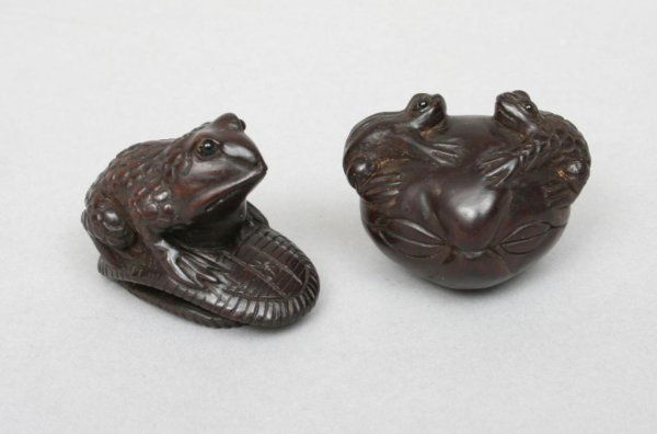 Two Boxwood Frog Netsukes: Mid to late 20th century, comprising one netsuke carved as a frog sitting on top of an over turned sandal, the base inset with an ivory signature (1 1/4"H. 7/8"W. 1 1/2"D); together with a boxwood net