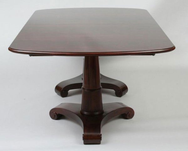 Baker Thomas Pheasant Collection Dining Table: Made by Baker Furniture Company, from the Thomas Pheasant Collection, the ovoid top in flame mahogany, raised over a flared double pedestal base on scrolled tripod legs, with two leaves. 29"H. 75"W. 4