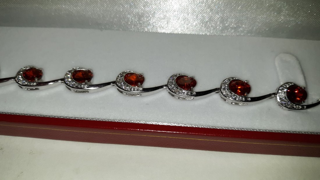 4.11 ct garnet tennis bracelet: 4.11 ct garnet tennis bracelet length 7" un marked lab created stones with presentation box see pics