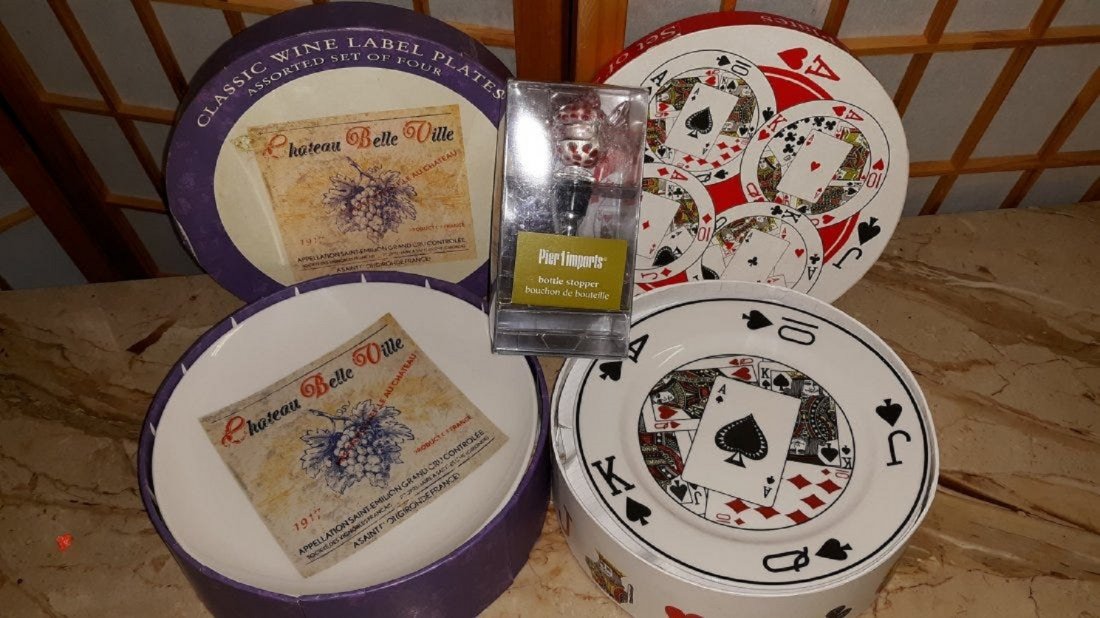 Mixed lot 8 plates and bottle stopper from pier 1: bottle stopper is from pier 1 of a fish in orig box, 4 Nantucket Home Cards Plates in original decorated box and classic wine label plates assorted set of four in an original decorated box no damage a