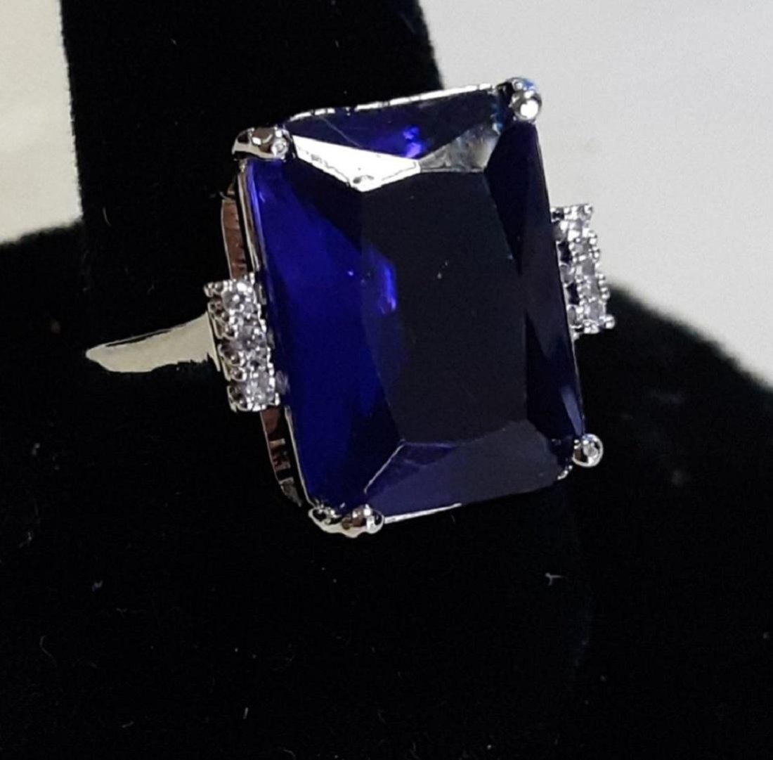 Sterling & Sapphire Ring Sz 6 1/2 jewelry: ring marked 925 with an emerald cut center blue sapphire man made? appx 5 carats with side white sapphires accents both likely man made but gorgeous sz 6 1/2 and in excellent condition see pics