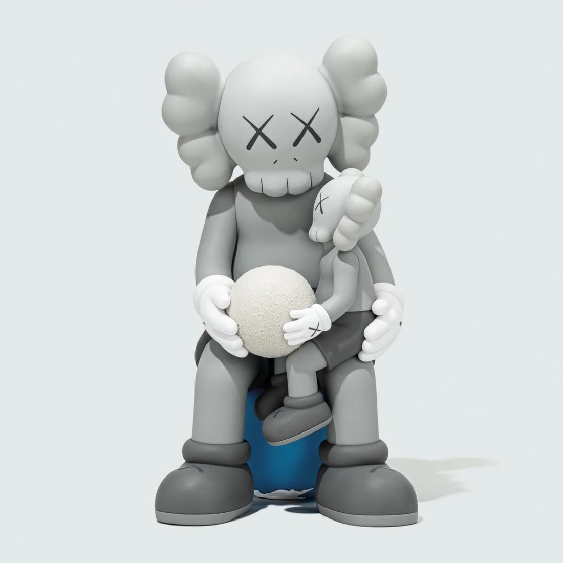 Kaws- Vinyl Figure "Holiday Thailand- Grey": Artist: Kaws. Medium: Vinyl Figure. Title: Holiday Thailand- Grey. Size: 11" x 6.7". Additional: Size: 11 x 5.9 x 6.7 inch. Glow in the dark. Comes in original box. Reference#: 86479.