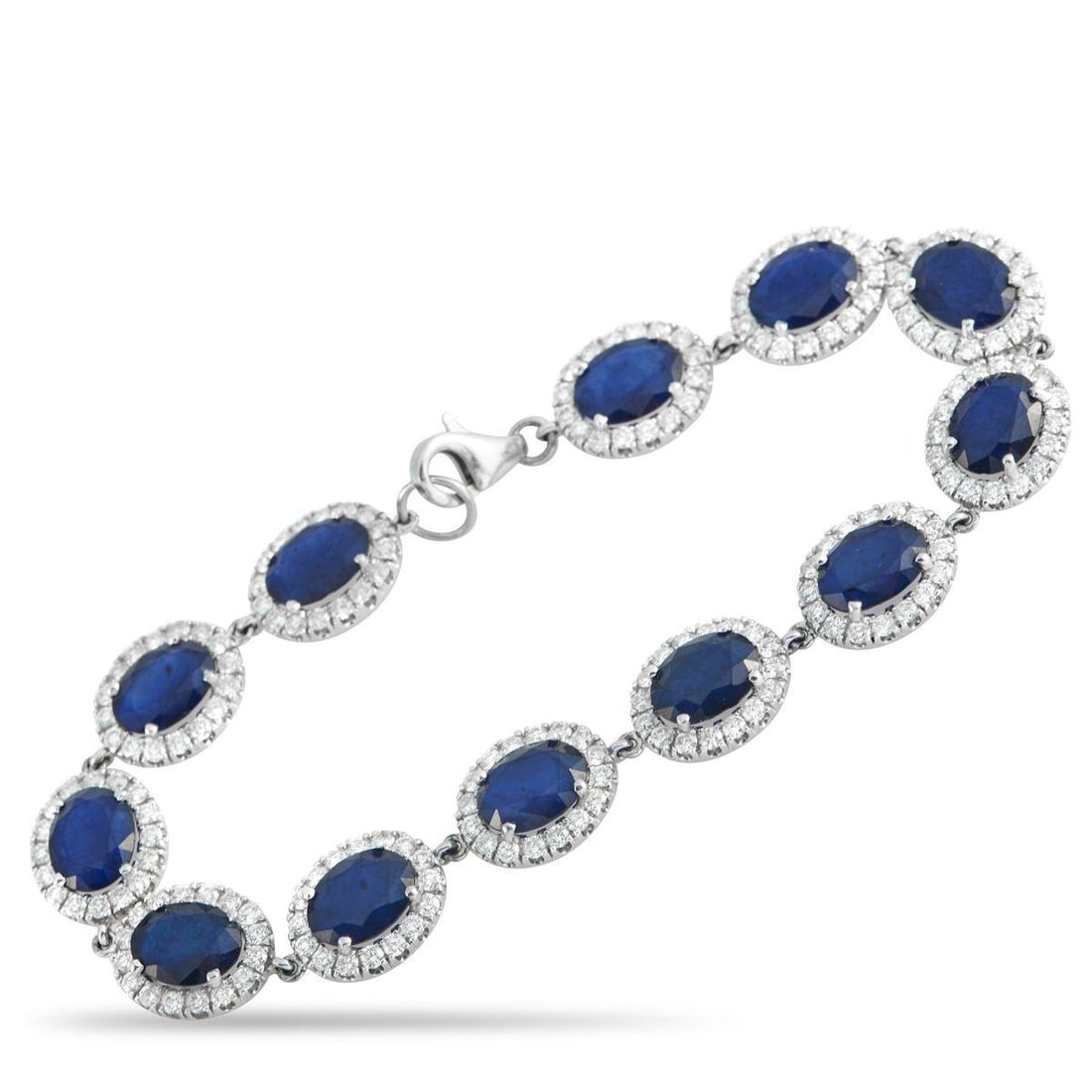 18K WHITE GOLD 4.92CT DIAMOND AND SAPPHIRE BRACELET: Regal in bearing, this piece carries the poise of heirlooms once worn in court. The white gold bracelet is composed of oval sapphires totaling 24.23 carats. Each blue stone is held in four prongs and
