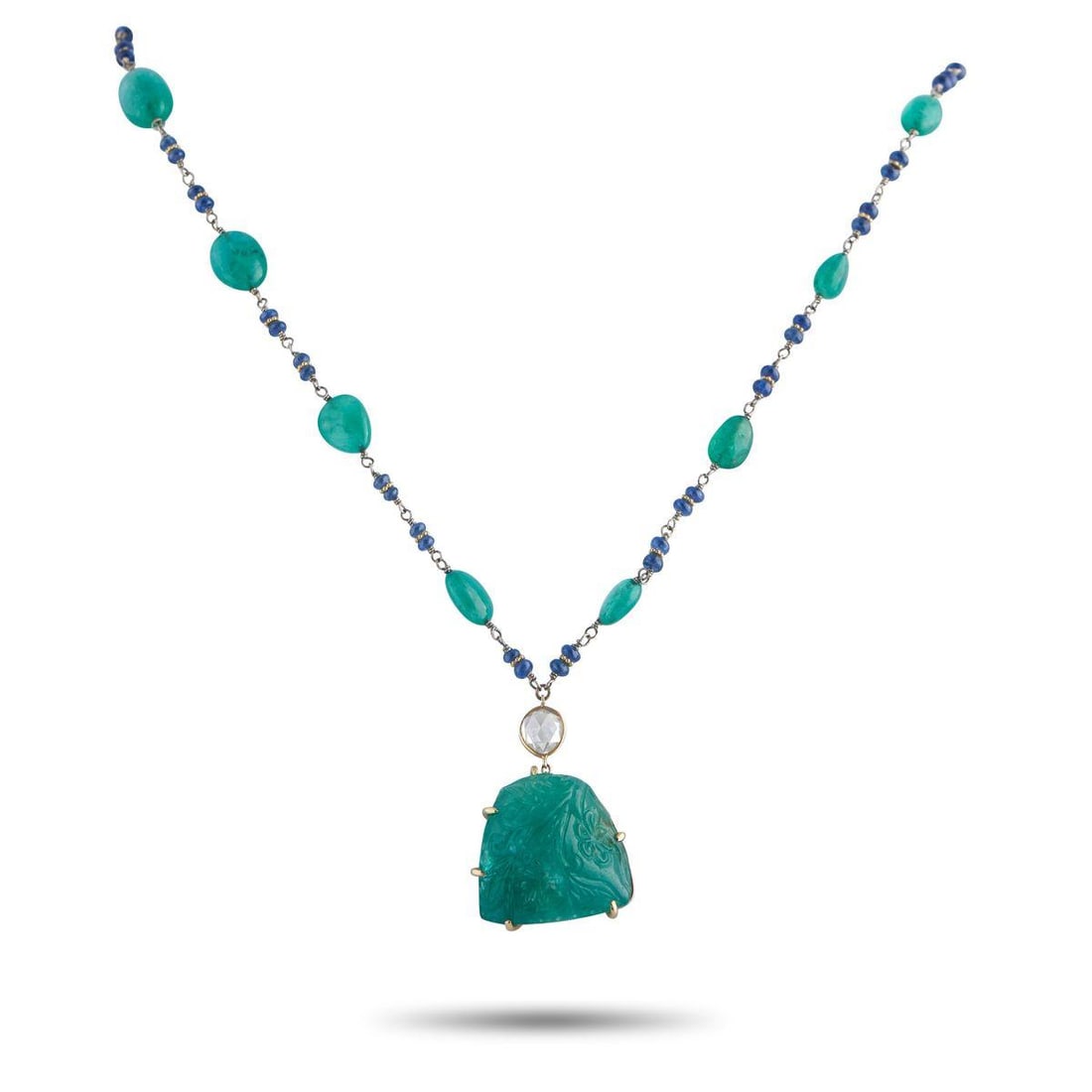 18K YELLOW GOLD 0.70CT DIAMOND AND EMERALD NECKLACE: This piece is an exploration of color and hand-worked detail. Along its 18K yellow gold chain are irregular emerald cabochons alternating with paired blue gemstone beads. Each emerald is slightly vari