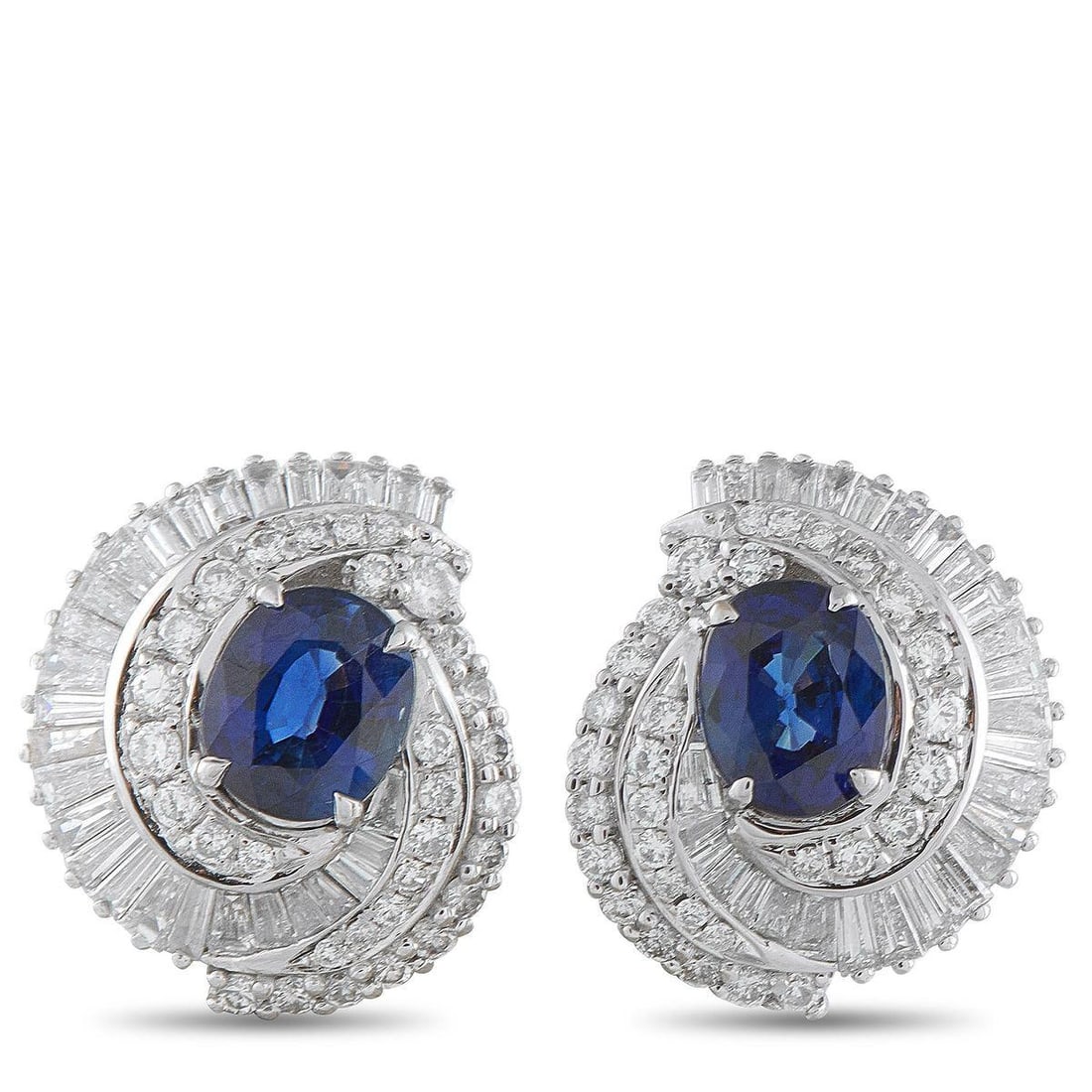 PLATINUM 1.50CT DIAMOND AND SAPPHIRE EARRINGS: Rich color and a swirl of brilliance mark these earrings. Each features an oval sapphire in a deep, royal blue hue, embraced by a spiraling halo of diamonds in both round and baguette cuts. The diamon