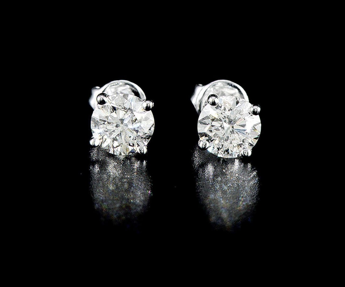 14kt White Gold 1.96ctw Diamond Earrings: One pair of 14k white gold earrings (585 stamped), each set with one natural enhanced diamond Jewelry Weight: 1.83Grs Total Diamonds Weight: 1.96Cts Main Stones Description: Quantity: 2 Cut and shape: