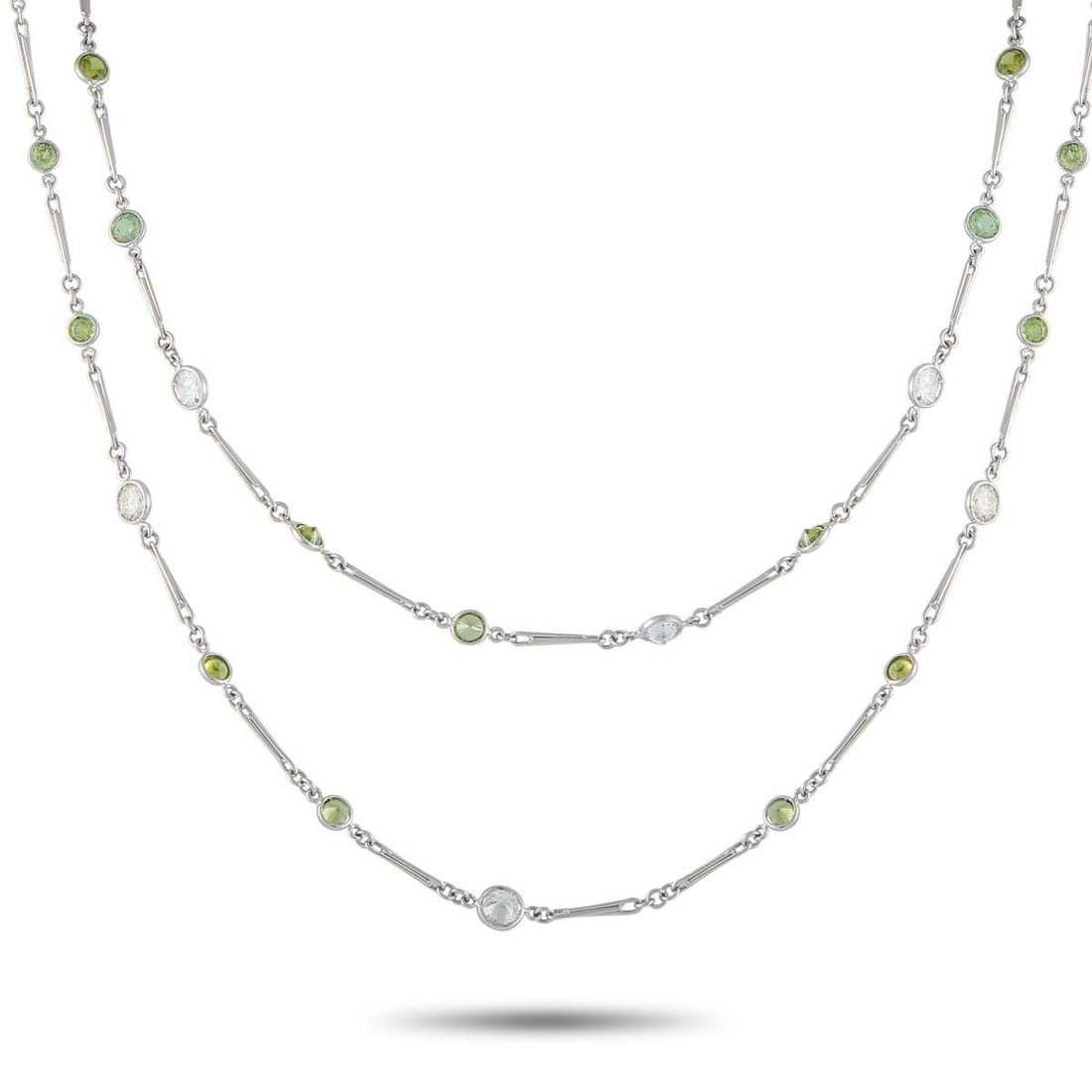 PLATINUM 7.13CT DIAMOND AND DEMANTOID NECKLACE: Add charm and sophistication to any ensemble with this elegant necklace. Glittering green Demantoid with a total weight of 22.92 carats contrasts beautifully against this pieces sleek Platinum