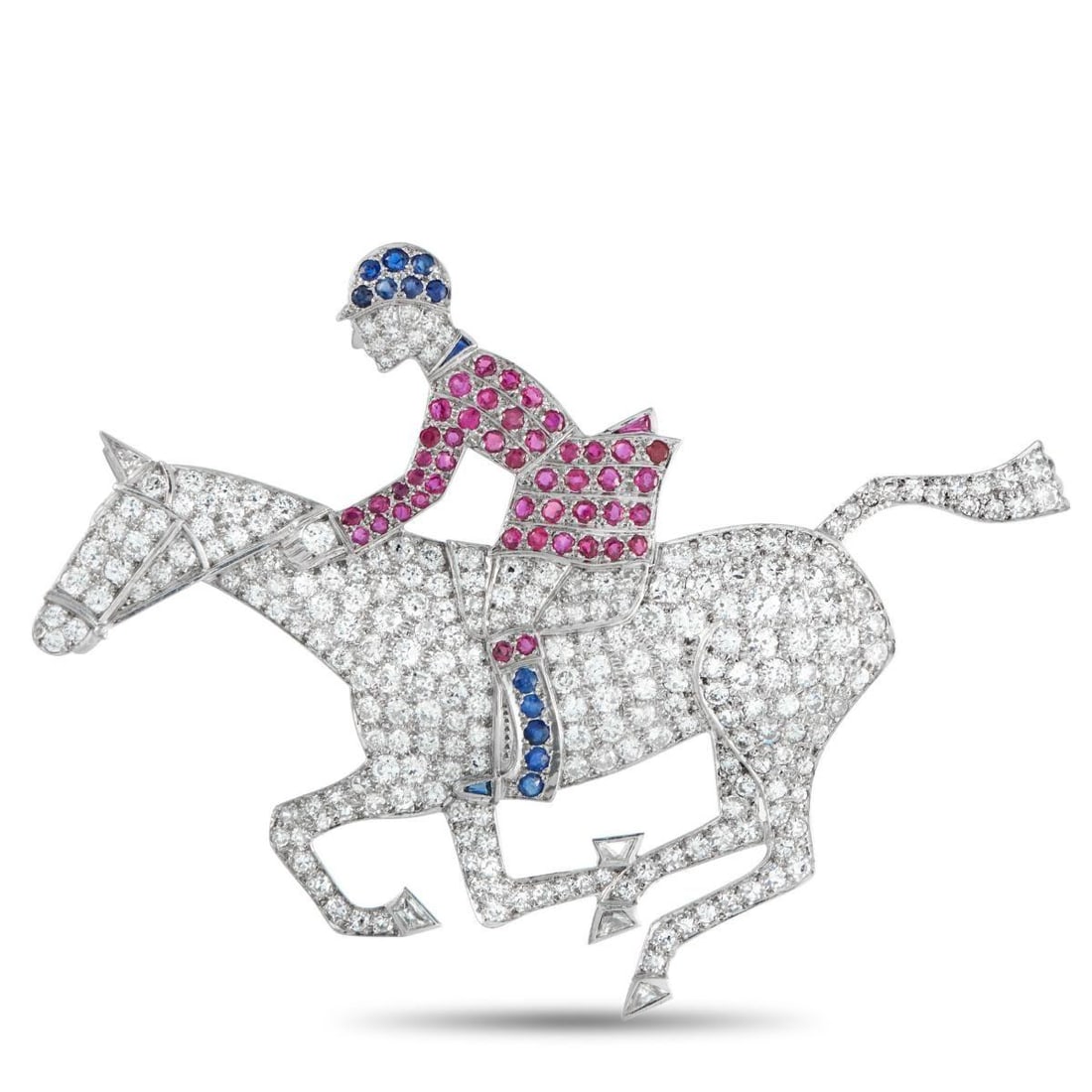 18K WHITE GOLD 6.50CT DIAMOND, RUBY, AND SAPPHIRE HORSE AND JOCKEY BROOCH: An equestrian design makes this brooch a sophisticated addition to any ensemble. Set in 18K White Gold, inset Diamonds totaling 6.50 carats make it the perfect piece for any luxury jewelry collection.